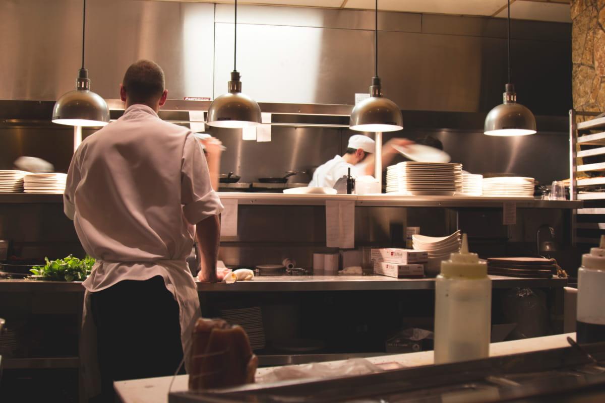 Personal de un restaurante trabajando diligentemente en una cocina ocupada, preparando deliciosas comidas.