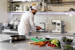 Chef preparando ingredientes frescos: ejemplo de estrategias de restaurantes para el Día del Padre con menús especiales.