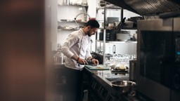 Chef cortando comida en la cocina de un restaurante, en referencia a una cocina fantasma.