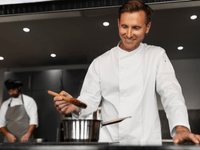 Chef de cozinha sorridente em uma dark kitchen especializada em delivery