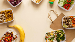 O Gemini disse Esta imagen muestra una selección de comida preparada para llevar o para entrega a domicilio, organizada en varios recipientes de plástico transparente sobre un fondo de color beige claro.