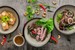 Fotografía de tres platos de comida instagrameable con fondo marrón.