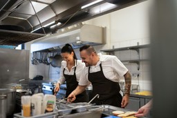 Cozinheiros trabalham em equipe com agilidade e organização, ilustrando como funciona uma cozinha pronta para delivery.